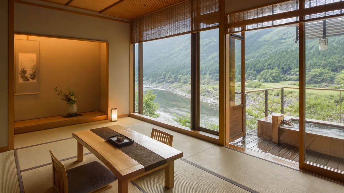 山と川を望む窓辺に座卓を備えた静かな和室
